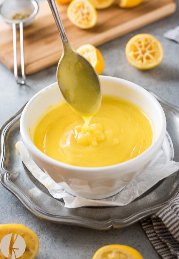 Lemon curd drizzling from a spoon into a bowl