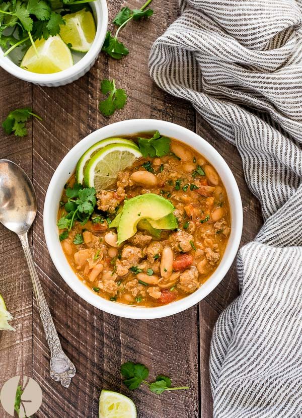 overhead shot of white bean turkey chili with avocado on top