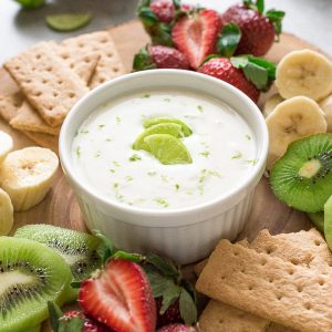 Key lime Greek yogurt dip on serving plate with fruit and graham crackers