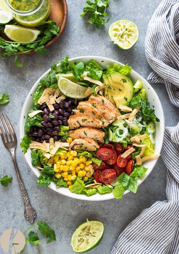 Santa fe chicken salad in white bowl with fork and lime