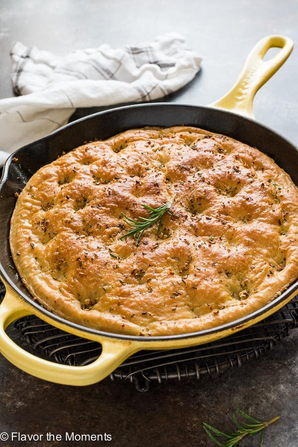 close up of one hour focaccia bread in skillet with rosemary on top