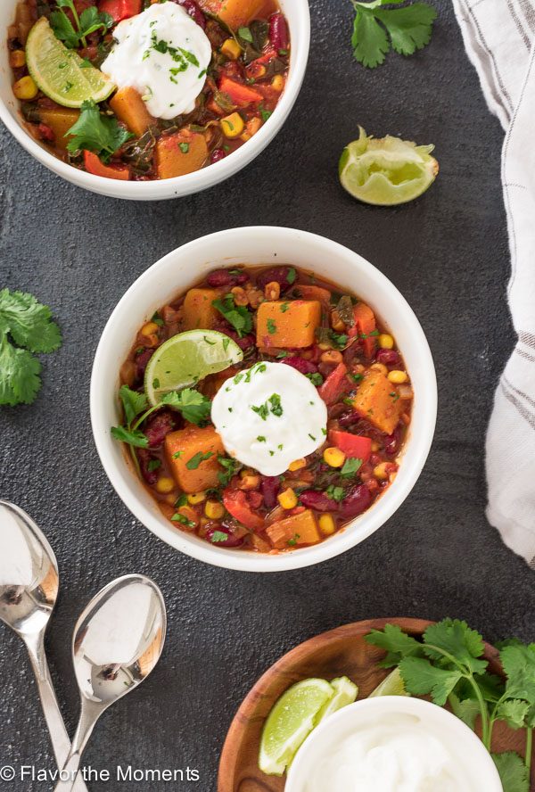Butternut Squash Stew in white bowl with lime, cilantro and Greek yogurt