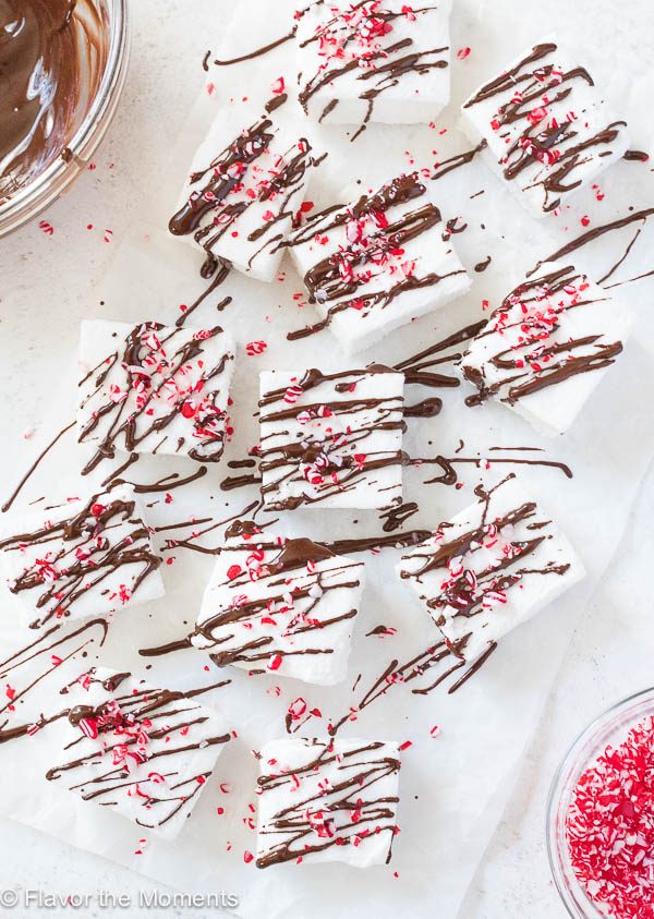Peppermint marshmallows on parchment paper drizzled with melted chocolate
