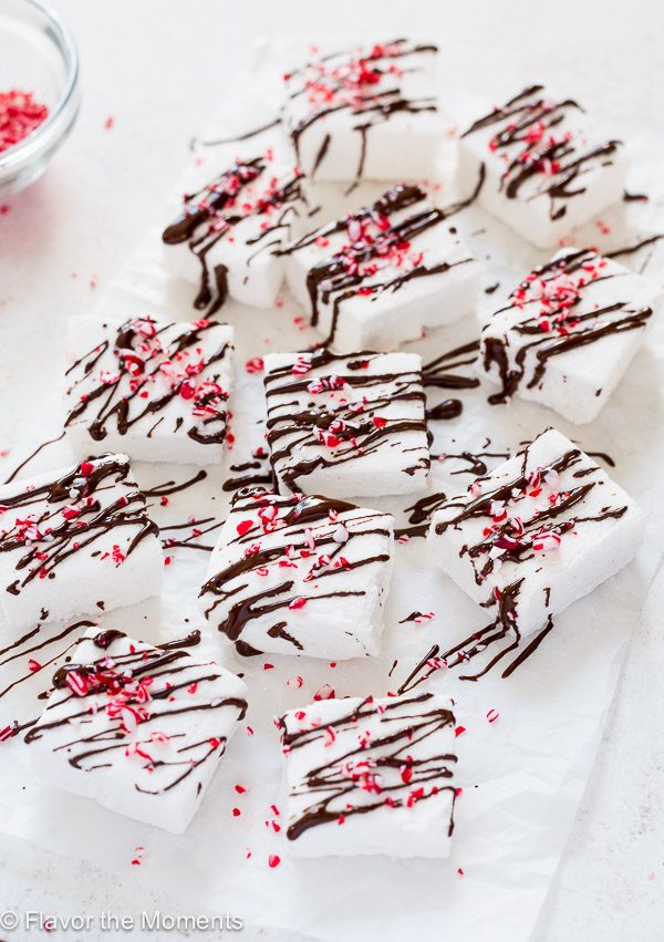 Peppermint marshmallows on parchment paper drizzled with dark chocolate