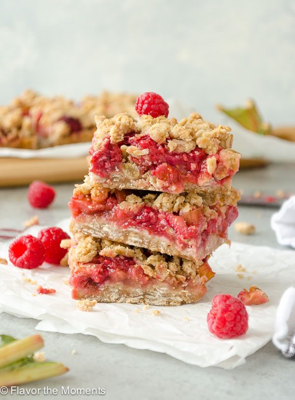 Three raspberry rhubarb bars stacked on top of each other. 