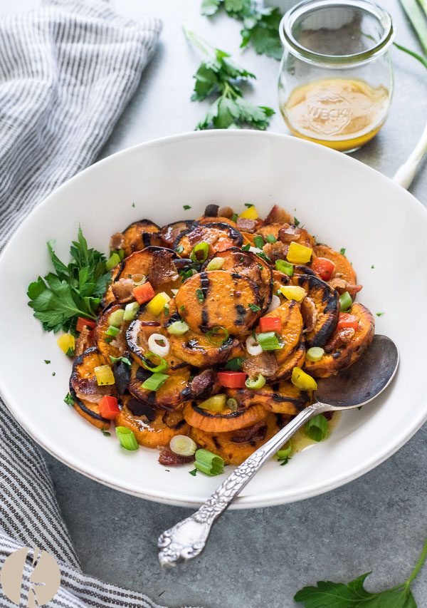 Grilled sweet potato salad in white bowl with spoon