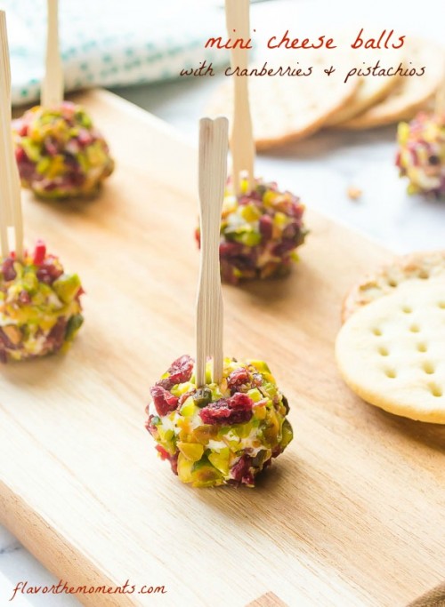 Mini cheese balls with pistachios and cranberries on cutting board