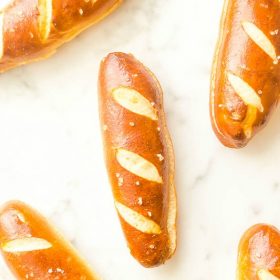 Soft pretzel hot dog buns on marble board