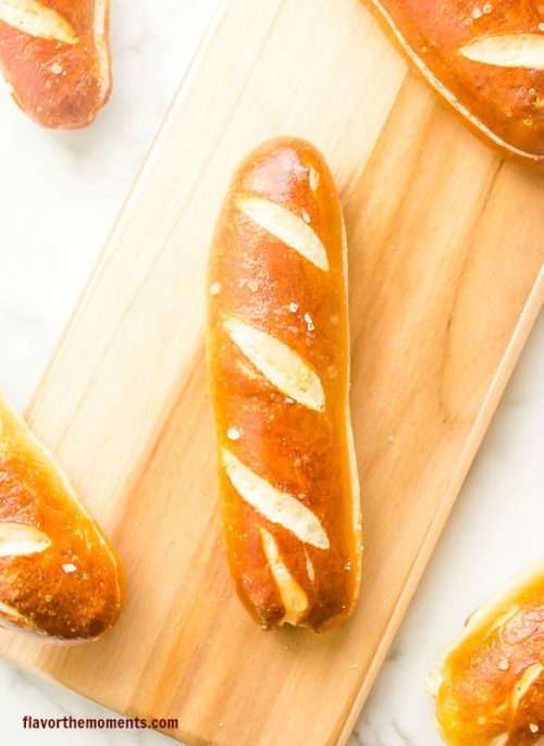 Soft pretzel hot dog buns on cutting board