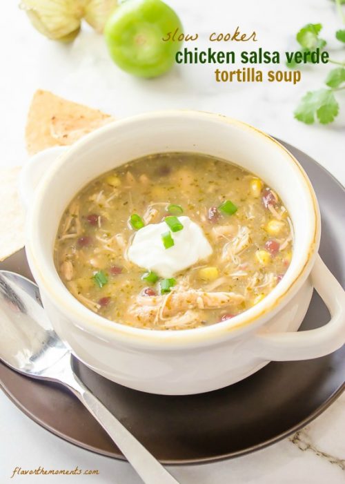 Salsa verde chicken soup in white bowl with sour cream on top