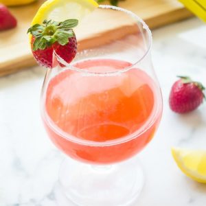 Strawberry lemon drop in glass with strawberry on rim