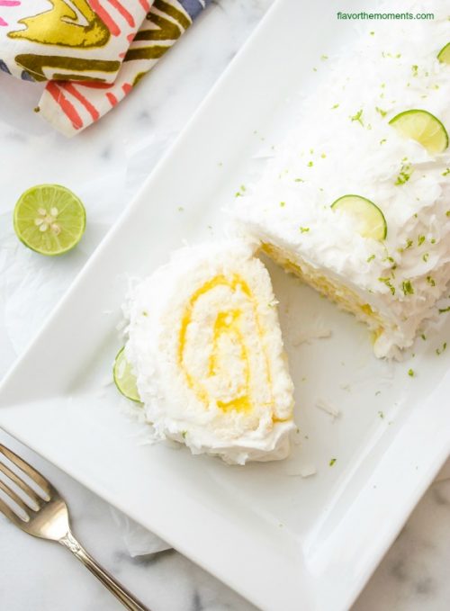 Coconut lime angel food cake roll on a white platter