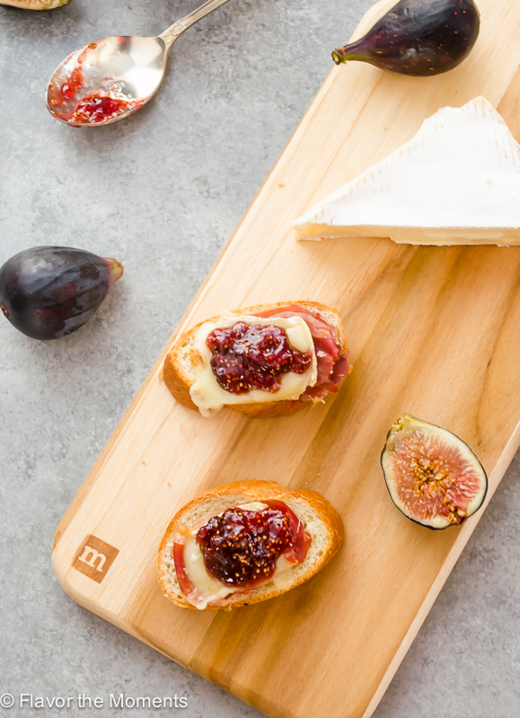 Brie and fig crostini on a cutting board