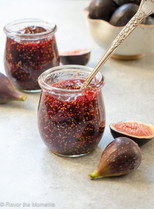 fig jam in a jar with spoon and fresh figs alongside