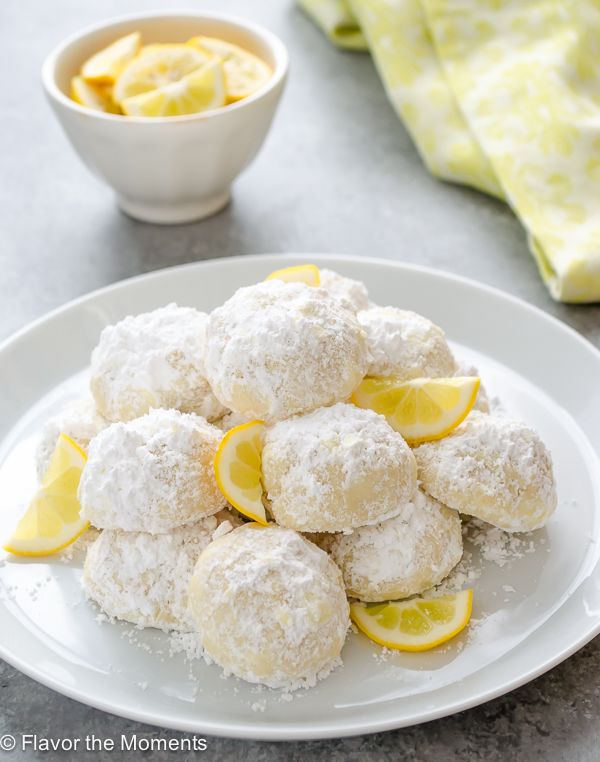 Meyer lemon Greek butter cookies or  kourabiedes on white plate with lemon slices