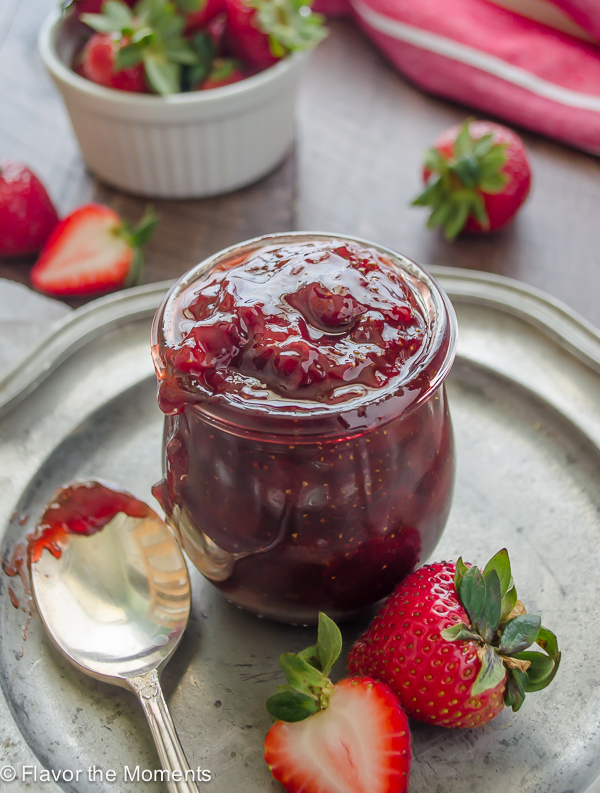 strawberry jam on silver plate with berries alongside
