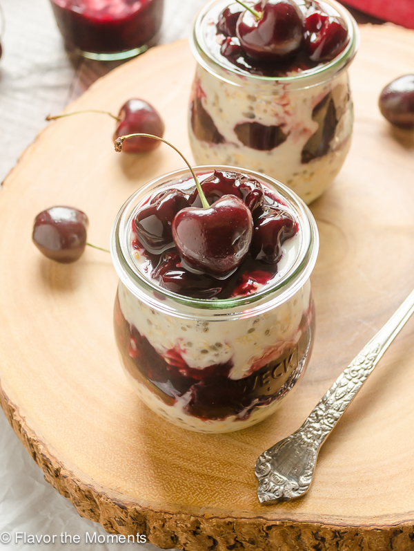 angled overhead shot of jar of cherry overnight oats with cherry on top