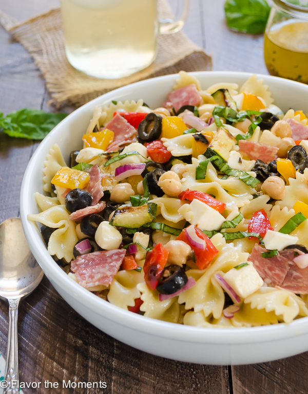 pasta salad with italian dressing in white bowl with spoon alongside