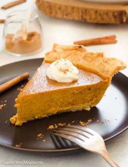 chai pumpkin pie on a plate with whipped cream