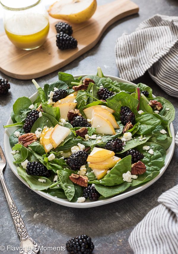 front shot of plate full of power greens salad with pears and blackberries