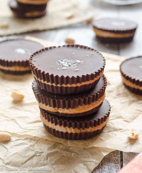 Three homemade peanut butter cups stacked on parchment paper