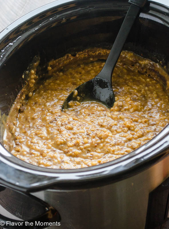 Pumpkin Steel Cut Oats in the slow cooker with a spoon in the center