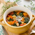 Autumn vegetable soup in a bowl with rosemary and parmesan on top
