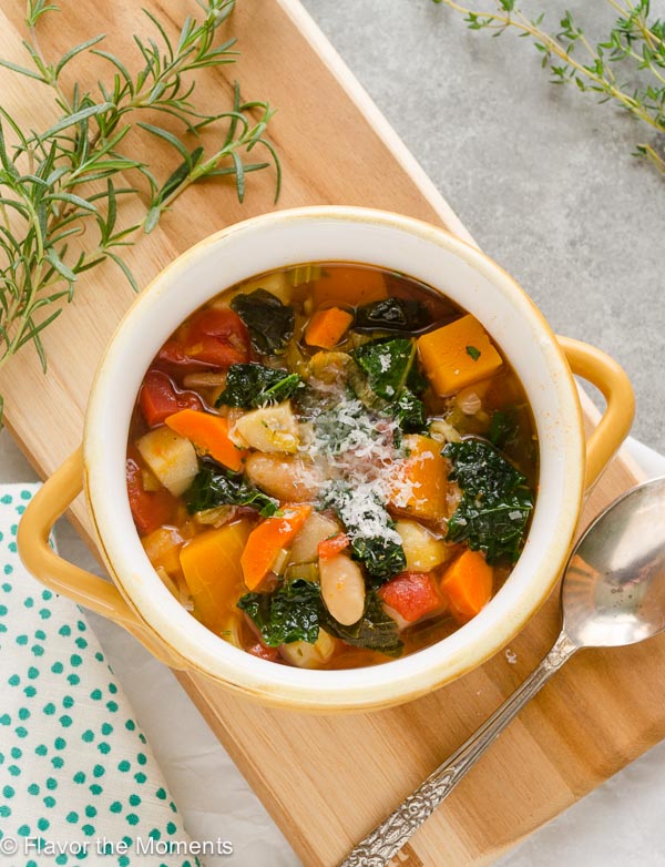 Overhead shot of autumn vegetable soup in bowl topped with parmesan cheese