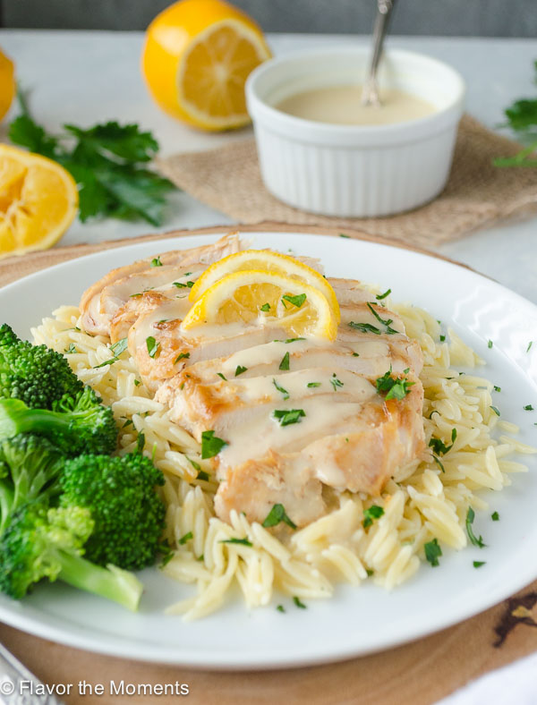 avgolemono chicken over a bed of orzo on a white plate