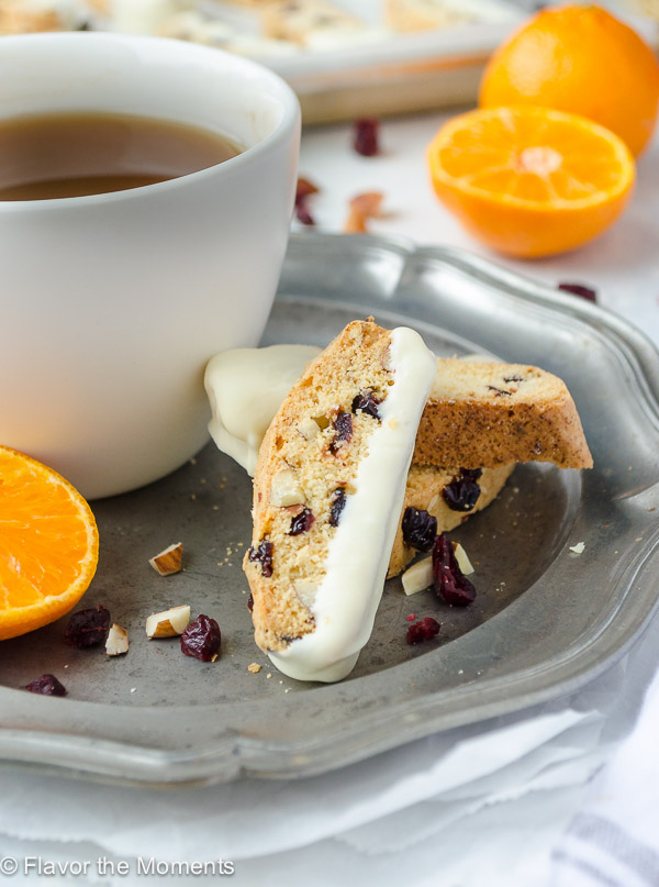 cranberry orange biscotti on plate with cup of tea