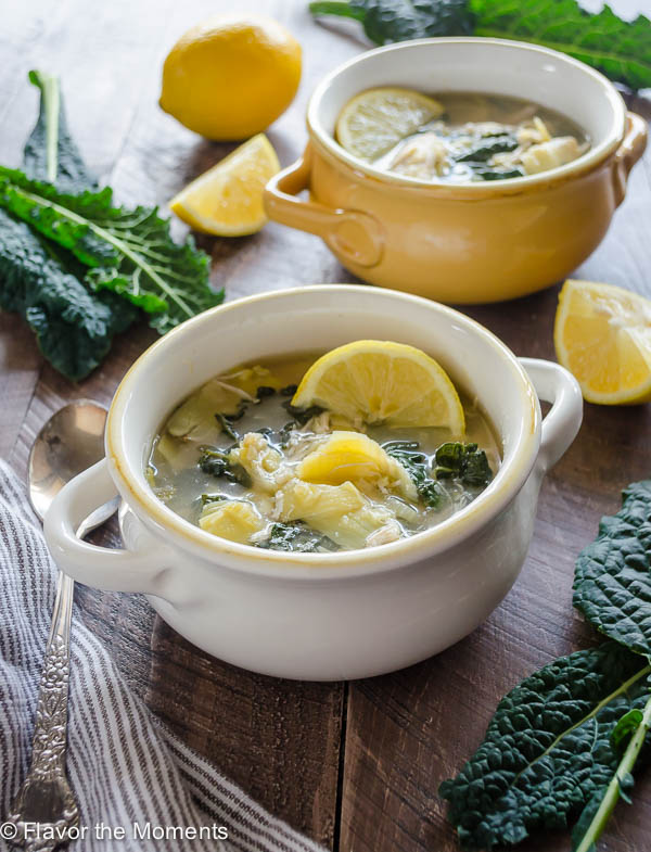 slow cooker chicken soup in white bowl with lemon slice on top