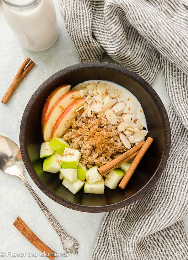 apple quinoa breakfast bowl with apples, almonds and yogurt on top