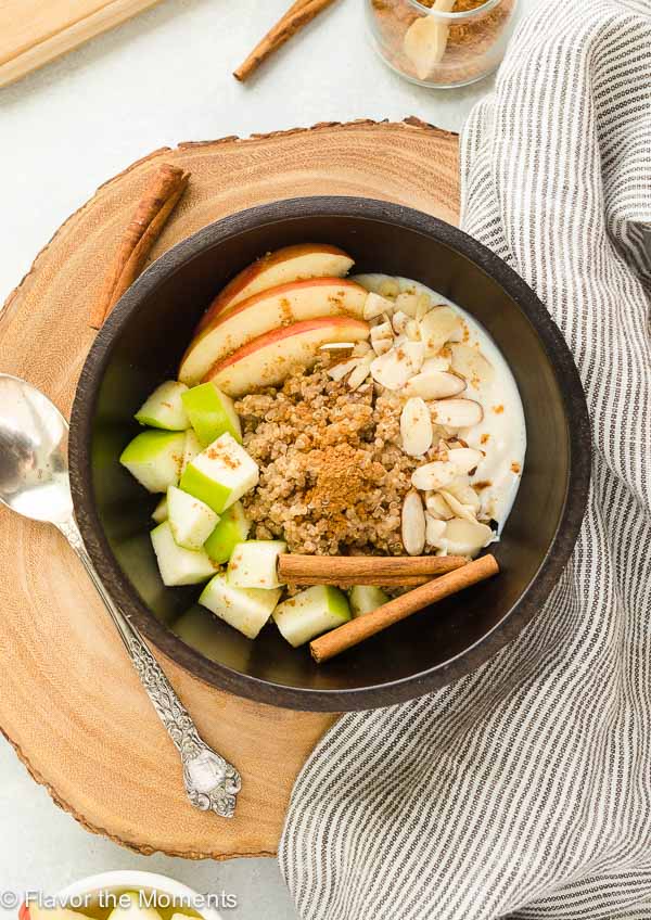 quinoa breakfast bowl on wooden server with spoon and linen