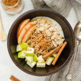 Quinoa breakfast bowls with apples and cinnamon sticks on top