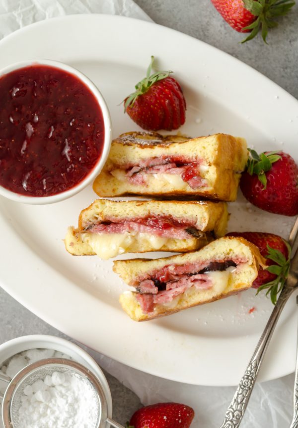 Monte cristo french toast on a plate with jam and strawberries