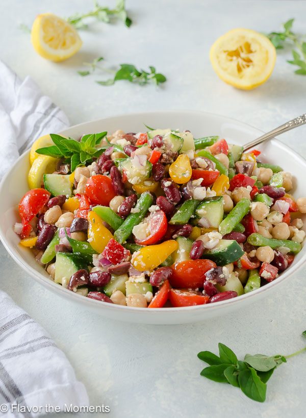 Greek three bean salad in white serving bowl with spoon