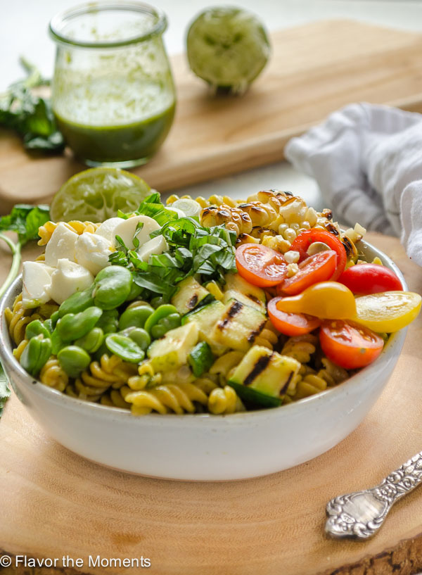 Grilled Vegetable Summer Succotash Pasta Salad is packed with grilled and fresh summer produce, fresh mozzarella pearls, and Chickapea gluten free pasta. It's tossed in a basil lime vinaigrette and is the ultimate summer pasta salad! @FlavortheMoment