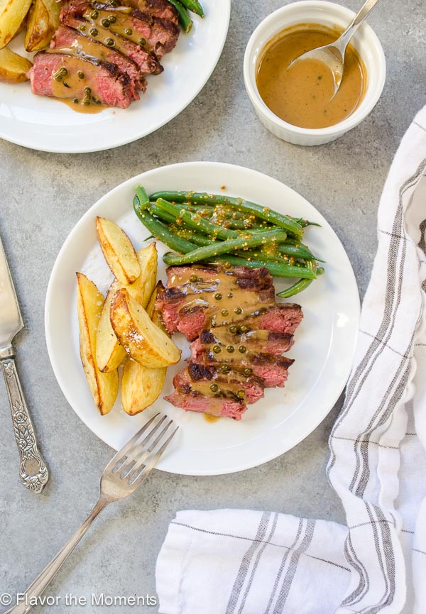 Plate of seared steaks, green beans and pommes frites