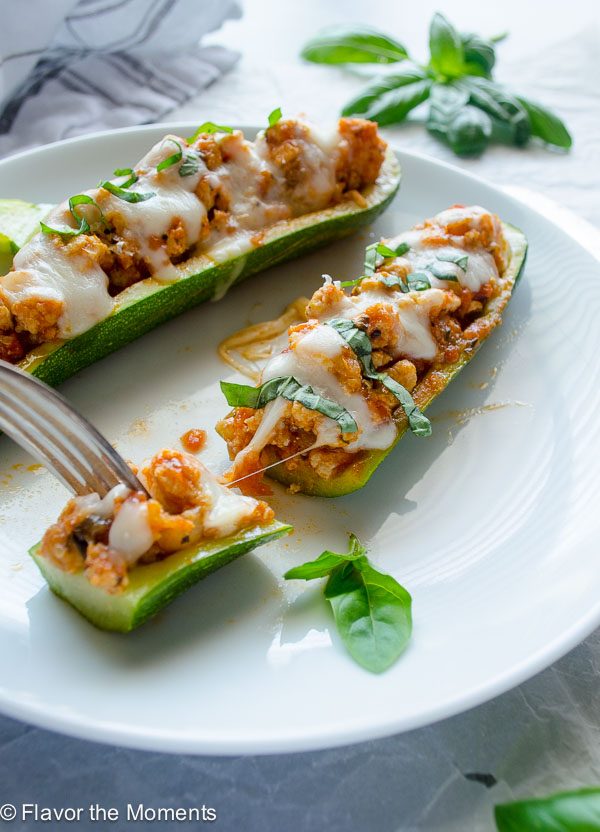 Bite of chicken parmesan zucchini boat pulling away with a fork