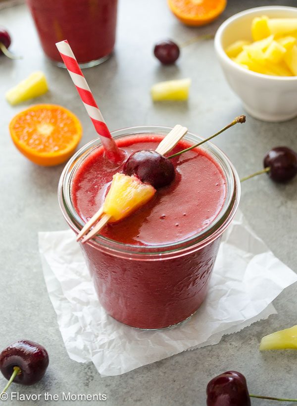 Cherry pineapple smoothie in jar with straw