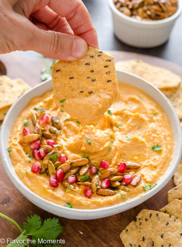 chip over a bowl of butternut squash hummus