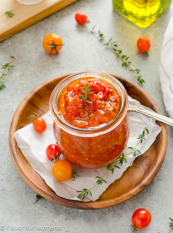 close up of cherry tomato jam in a jar with spoon