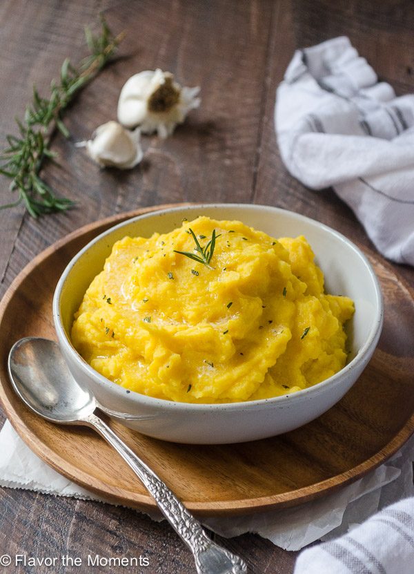 kabocha squash mashed potatoes in a bowl with rosemary on top