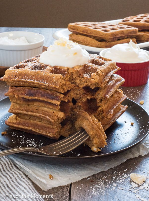 Gingerbread waffles on a plate with a bite on a fork