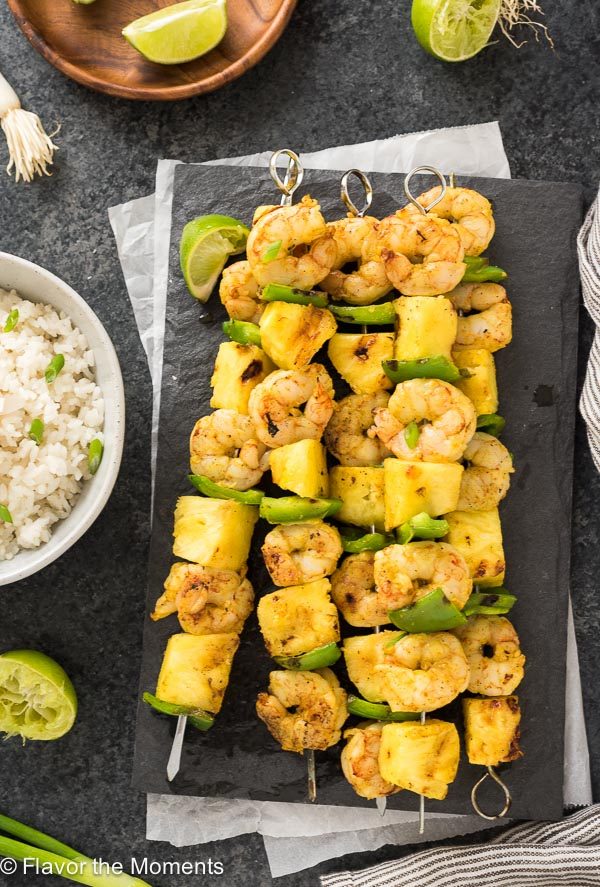 Curried shrimp skewers on platter with coconut rice