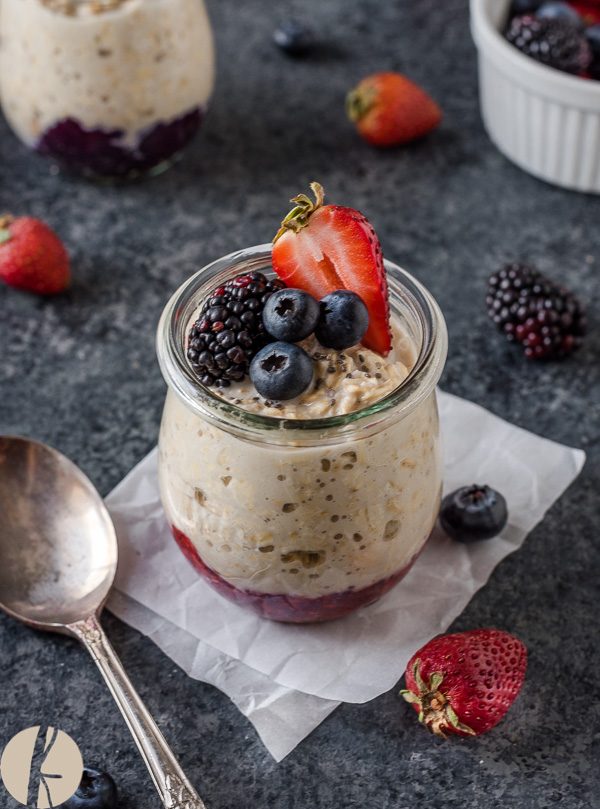Chia jam overnight oats in jar with berries on top