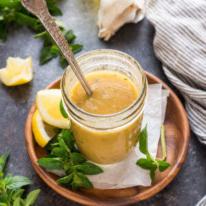 Greek salad dressing in a jar with spoon inside.