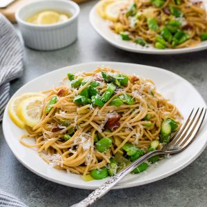 Spring spaghetti carbonara on a plate with bacon and fava beans