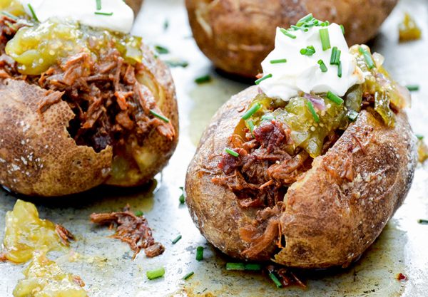 BBQ beef stuffed potatoes with sour cream and tomatillo salsa on top