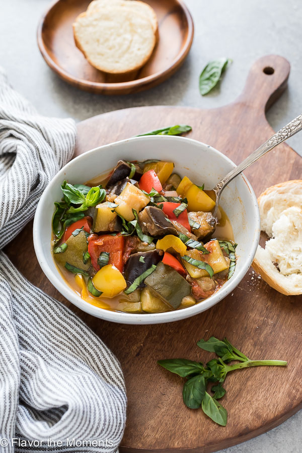 bowl of instant pot ratatouille with spoon in the bowl and bread alongside